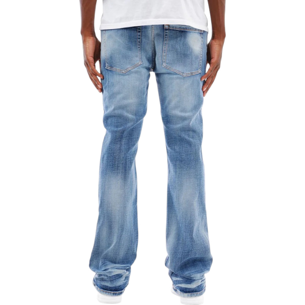 Light blue  flared stack jeans worn by a person on a white background