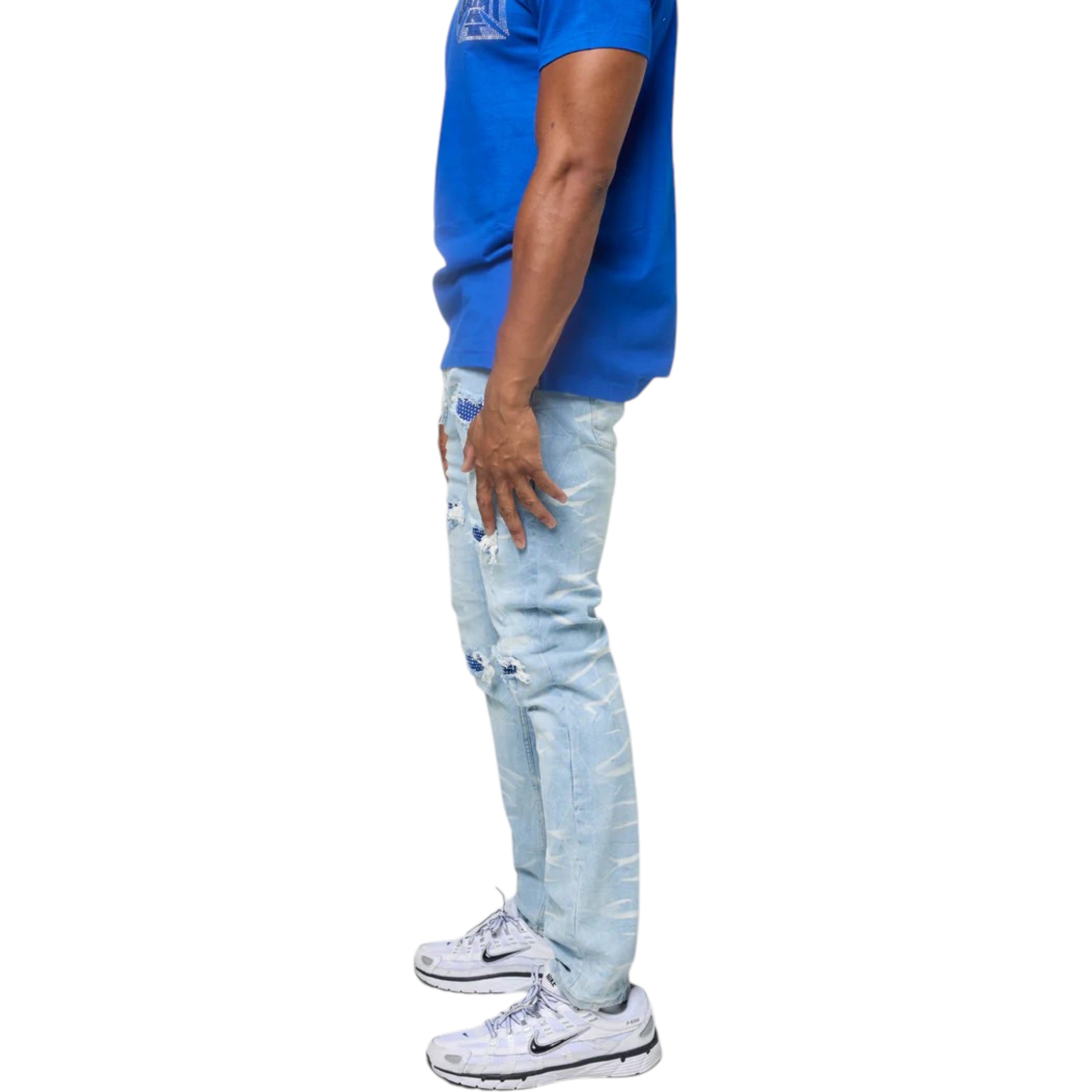 Person wearing a blue shirt and light blue ripped jeans on a white background