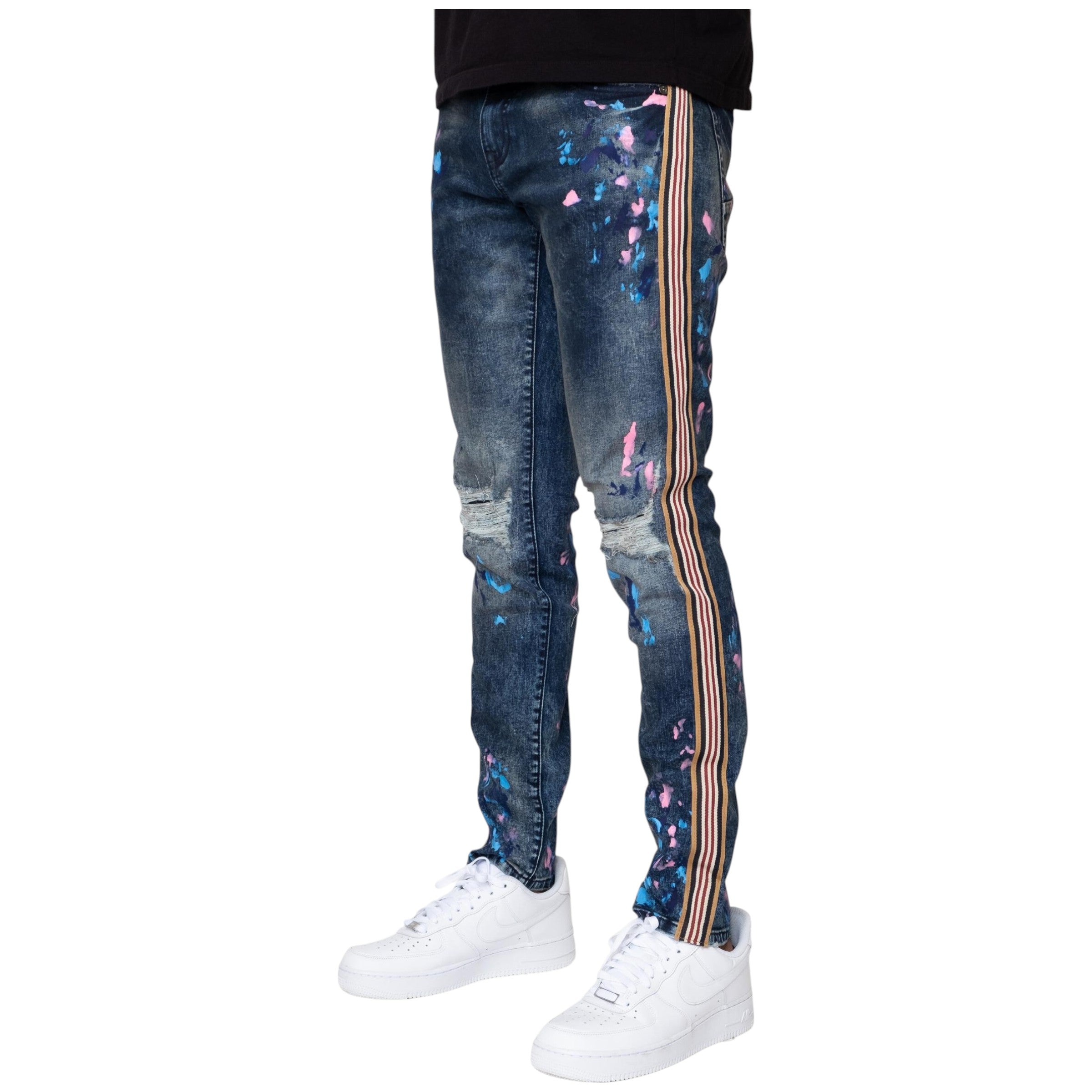 Blue jeans with colorful splatter design and striped side panels worn by a person on a white background