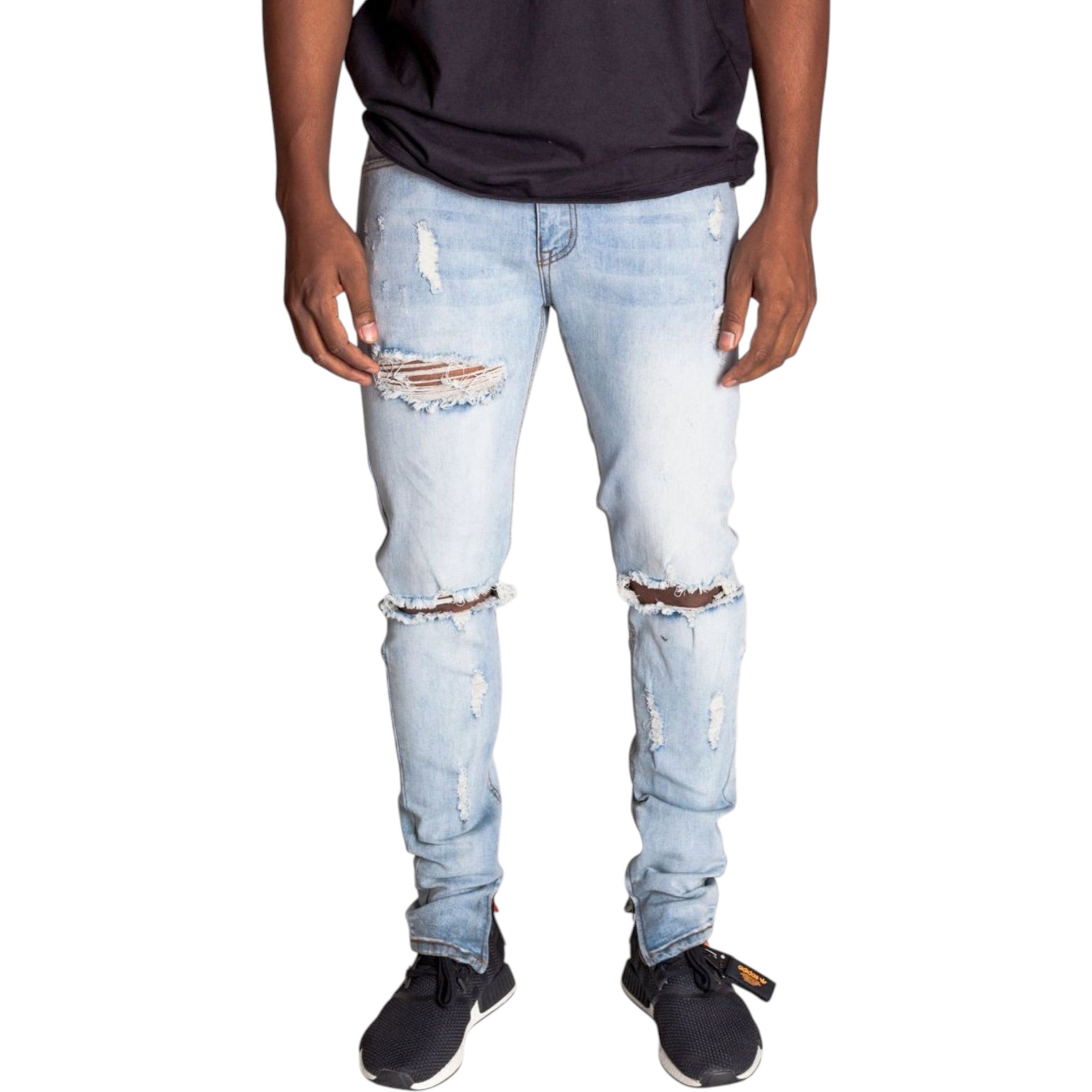 Person wearing light blue ripped jeans on a white background slim fit skinny fit 