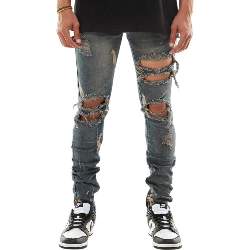 Ripped jeans worn by a person on a white background