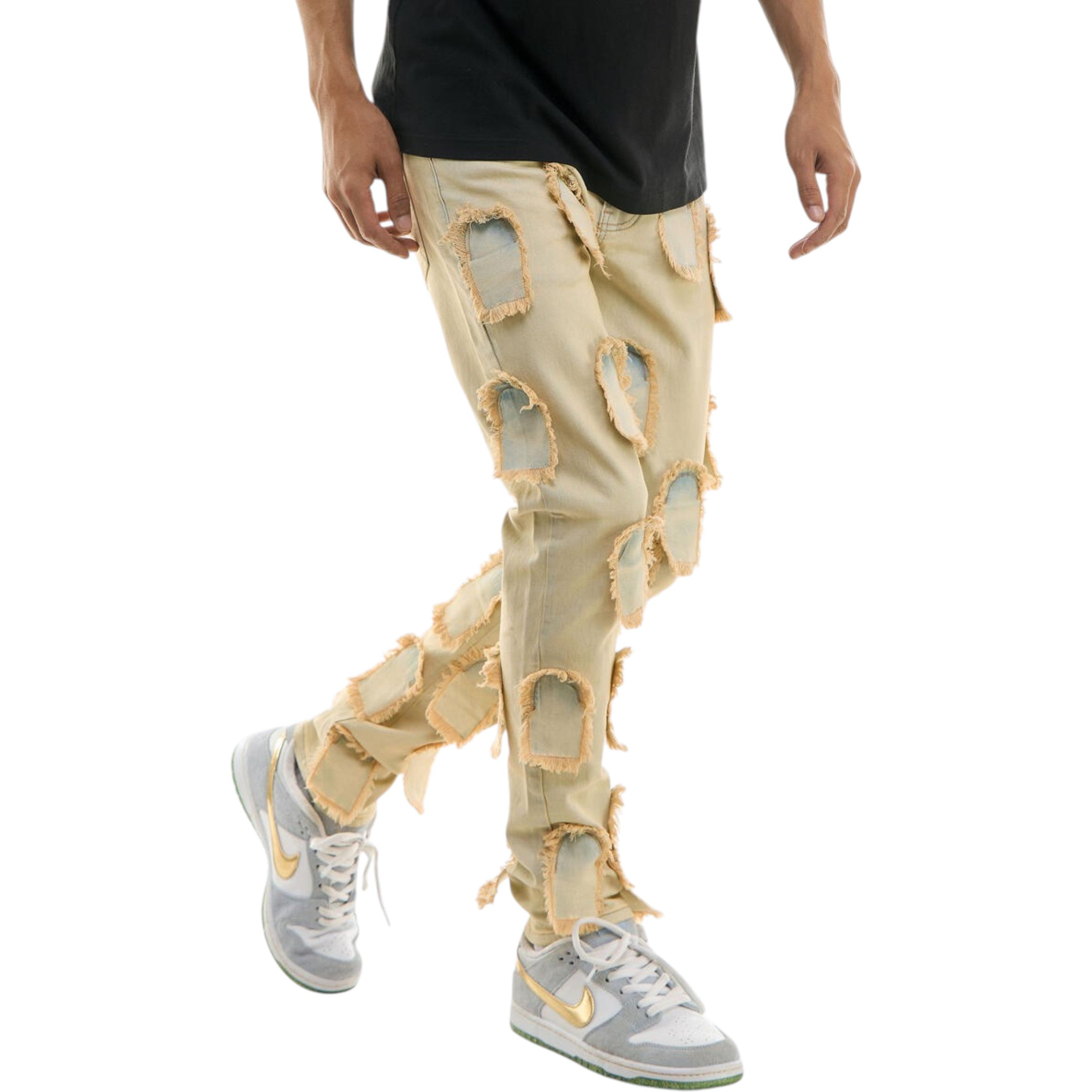 Person wearing beige pants with large cut-out sections and white sneakers on a white background
