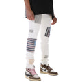 Person wearing white pants with colorful patches and brown sneakers on a white background