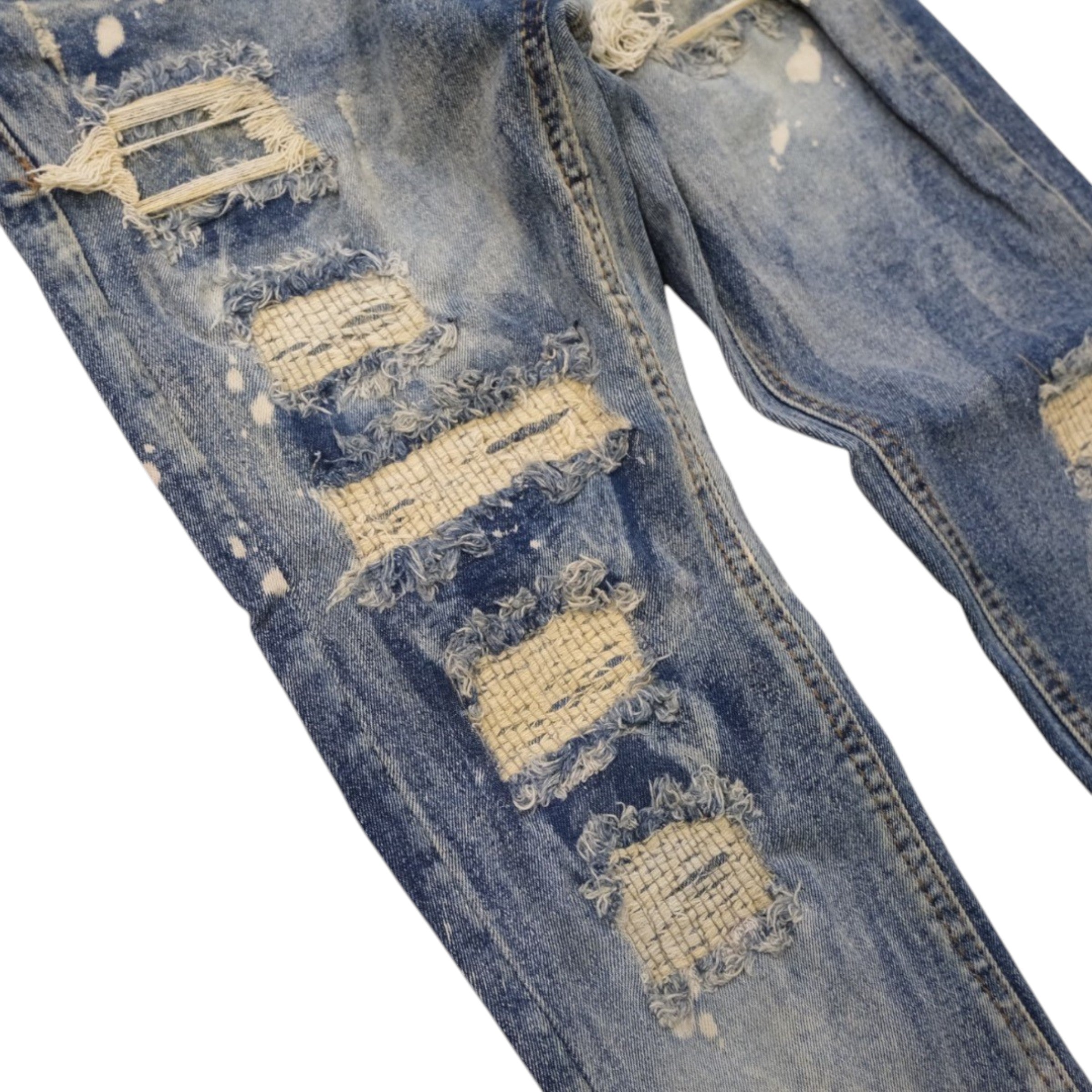 Distressed blue jeans with worn-out details on a white background