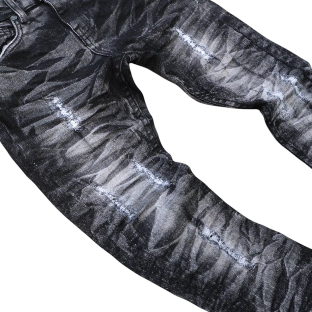 Close-up of black distressed jeans on a white background
