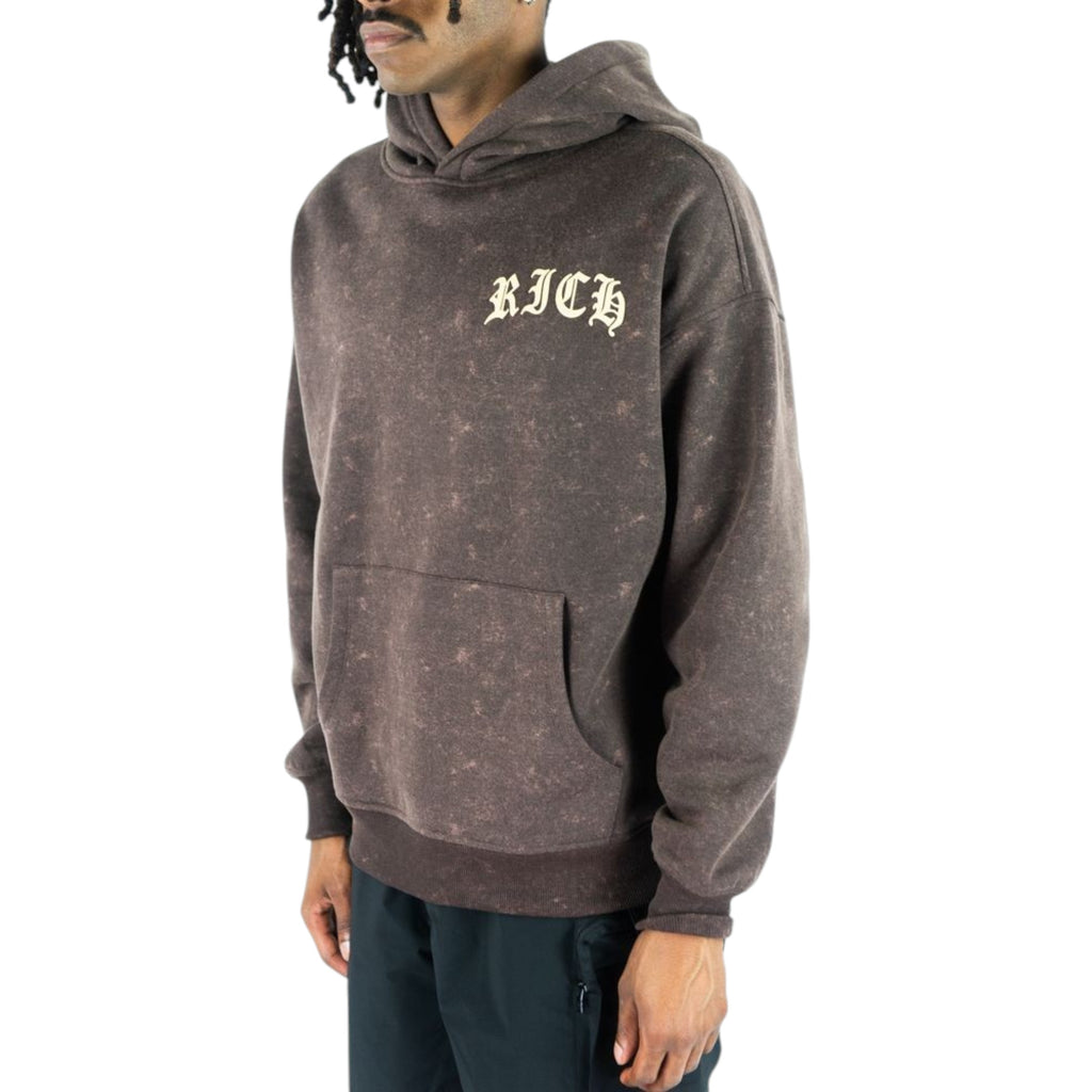 Person wearing a brown hoodie with 'RICH' text on a white background