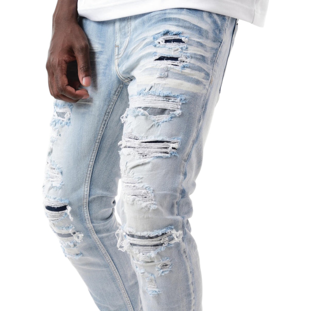 Light blue distressed jeans worn by a person on a white background