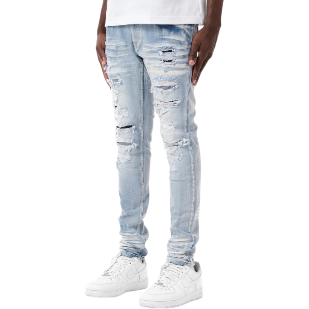 Light blue distressed jeans worn by a person on a white background