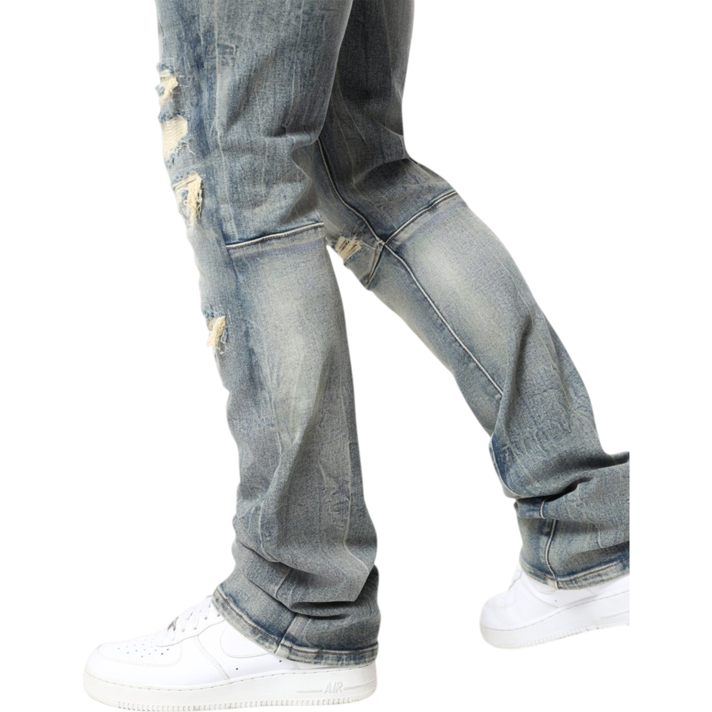Ripped blue jeans worn with white sneakers on a white background
