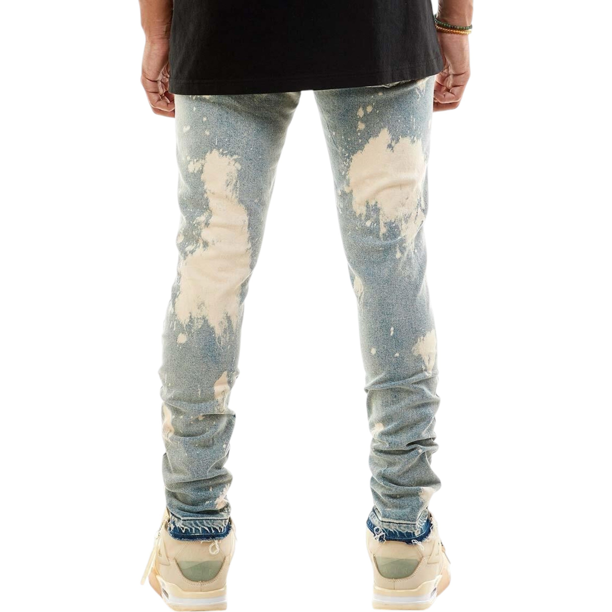 Distressed light blue jeans worn by a person on a white background