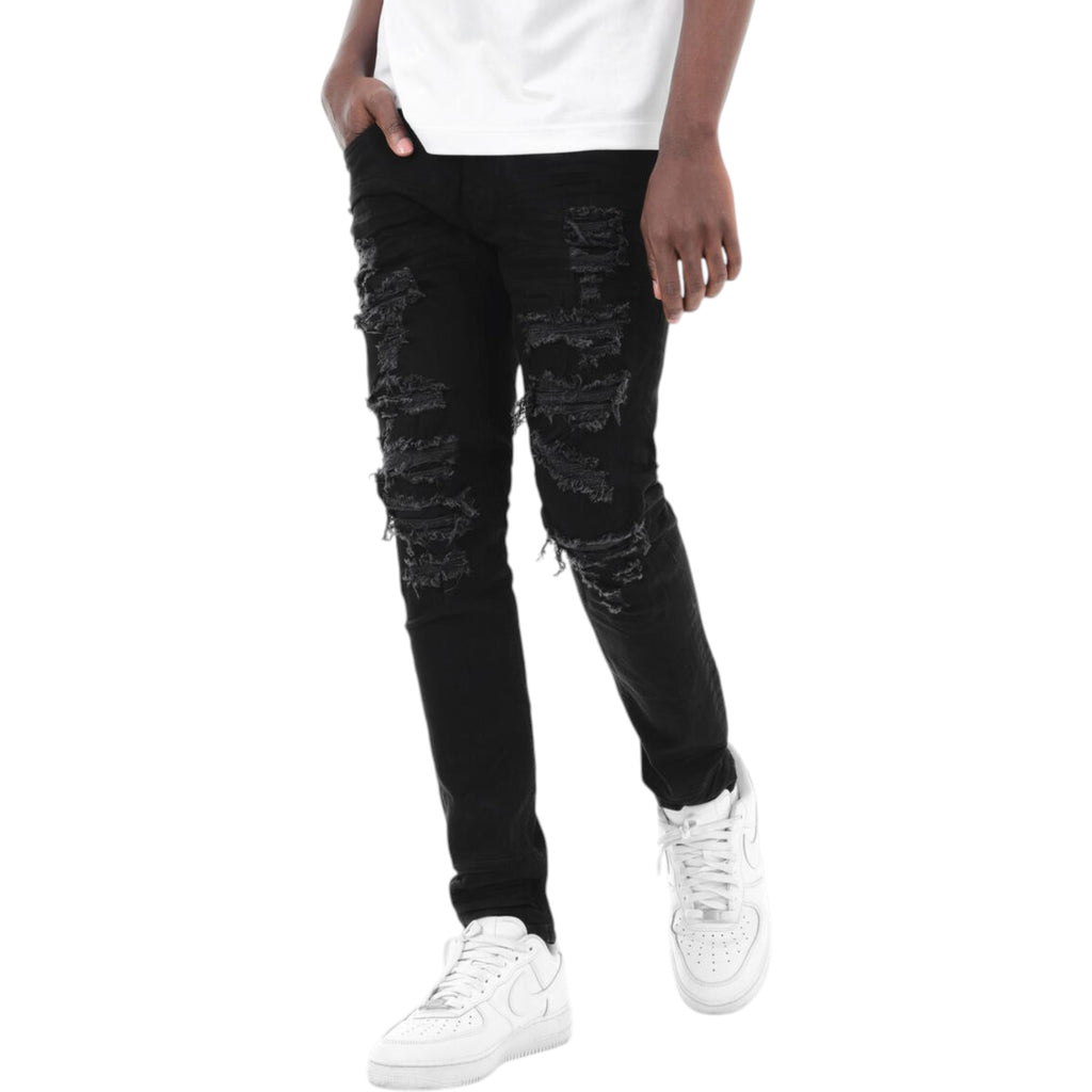 Person wearing black distressed jeans and white sneakers on a white background