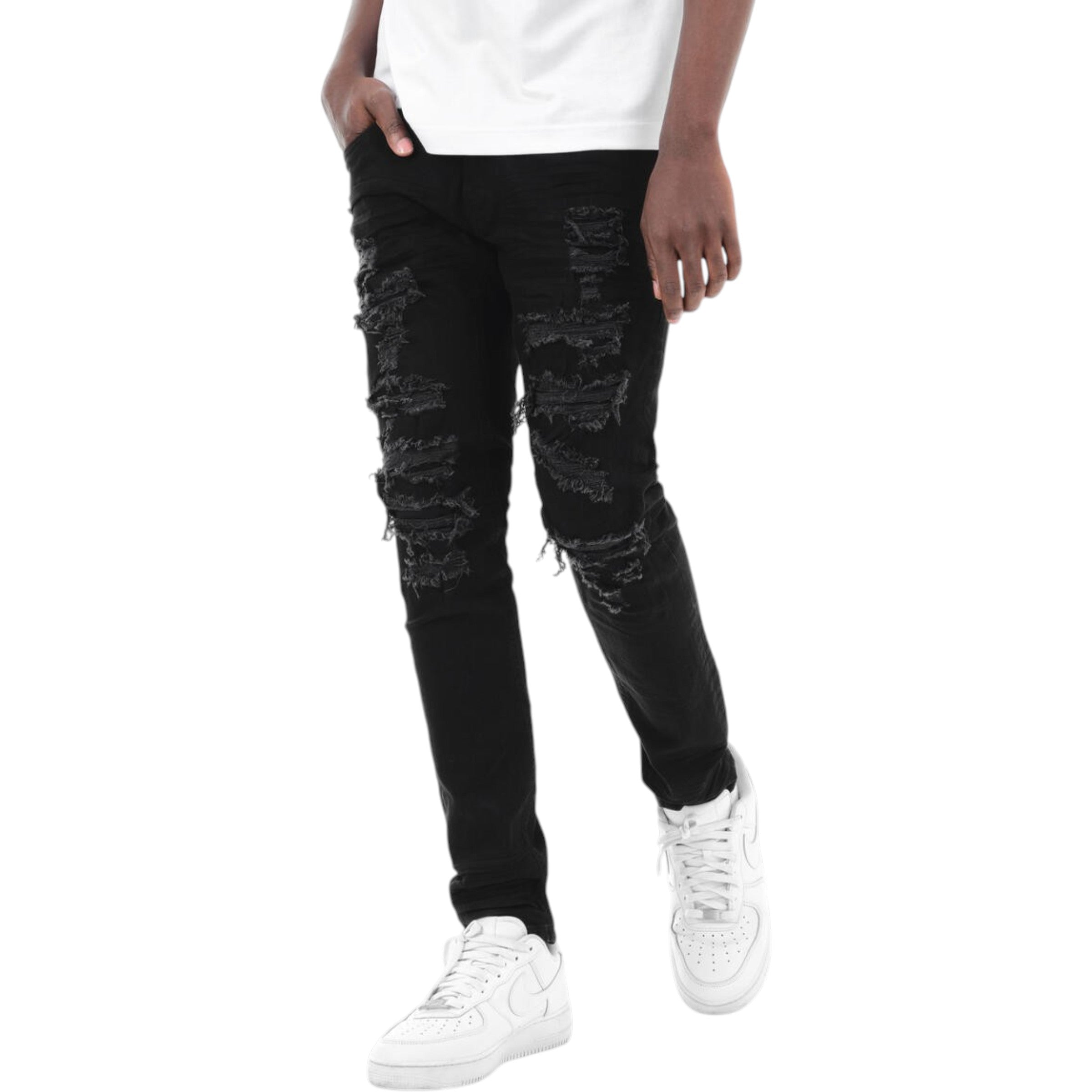 Person wearing black distressed jeans and white sneakers on a white background