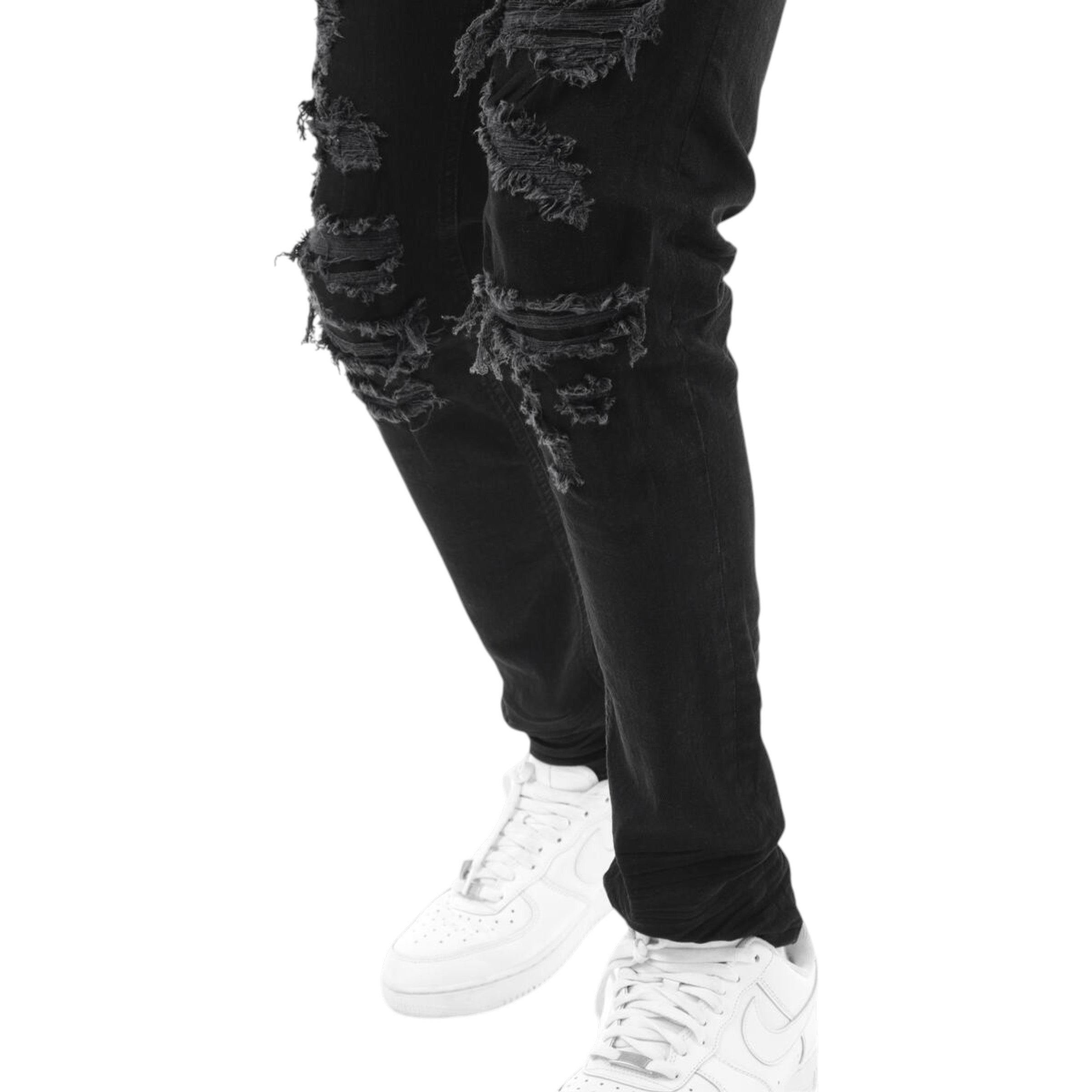 Black distressed jeans worn with white sneakers on a white background