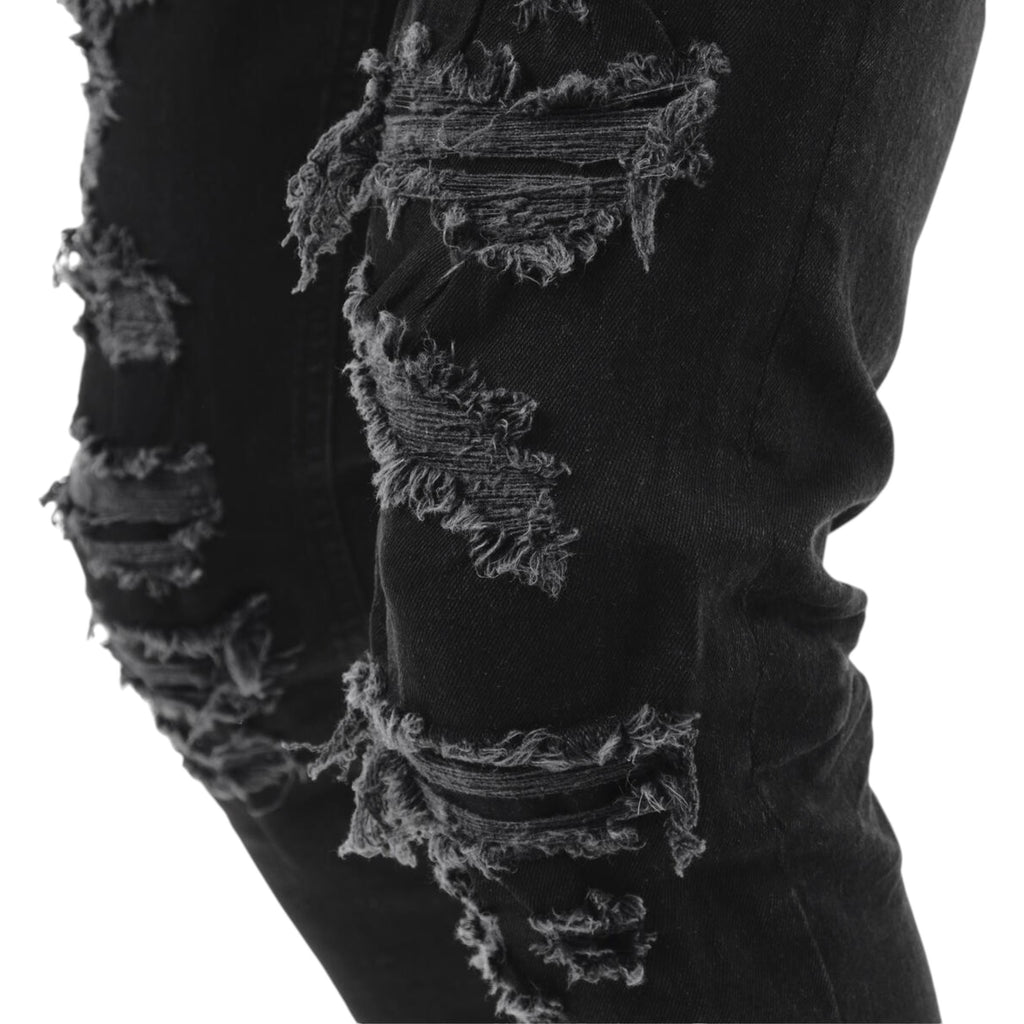 Black distressed jeans with a close-up of the ripped design on a white background