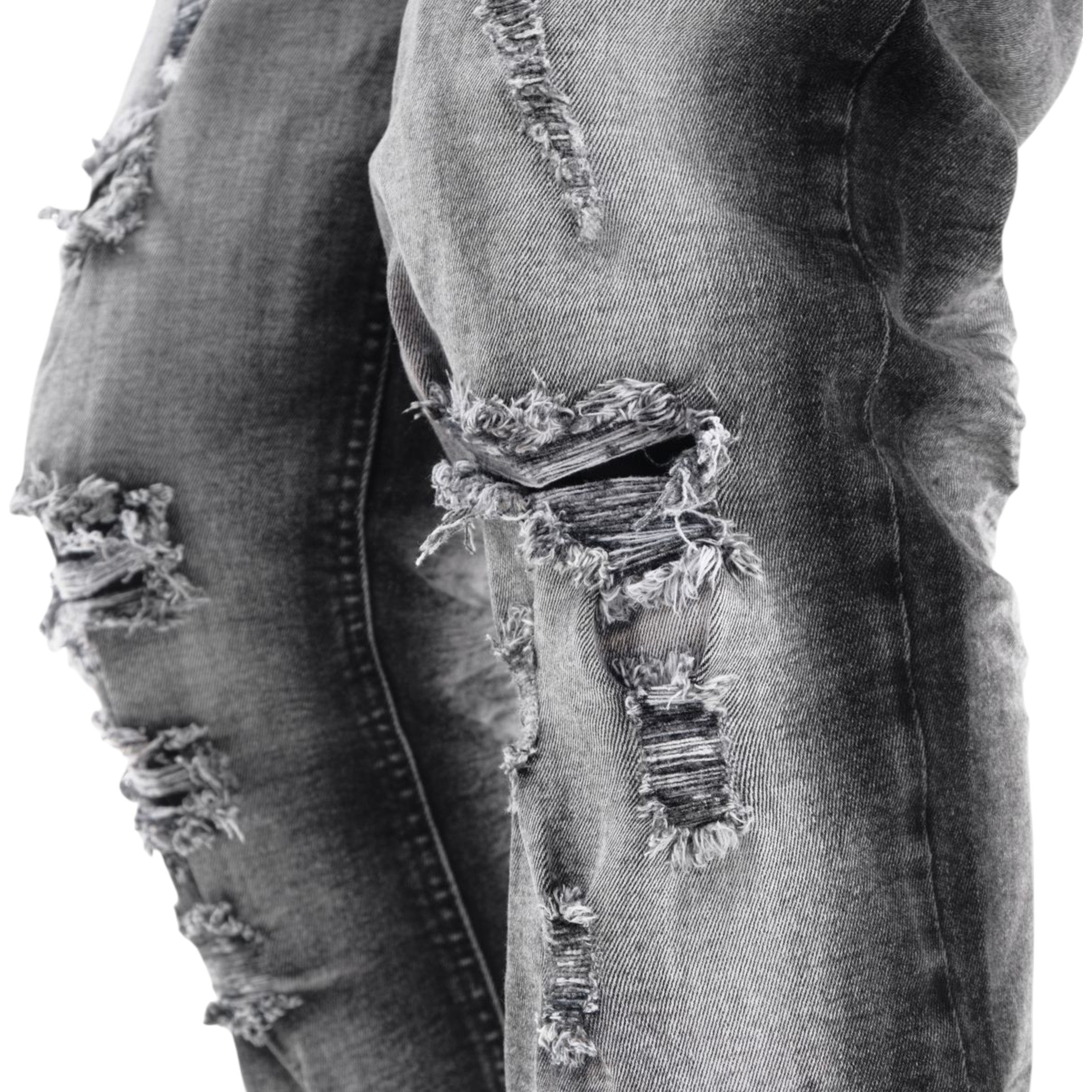 Ripped denim jeans with a focus on the distressed details.