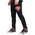 Black sweatpants with a logo worn by a person on a white background