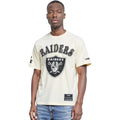Man wearing a white 'Raiders' t-shirt with a logo on a white background