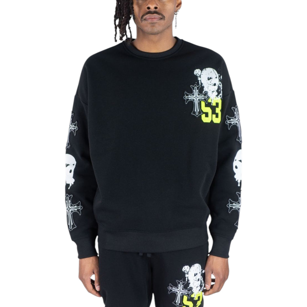 Person wearing a black sweatshirt with graphic designs on a white background