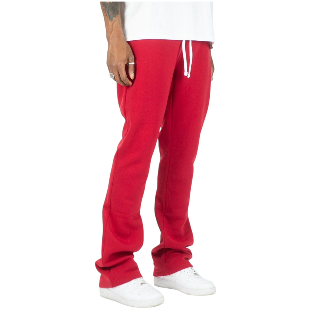 Red sweatpants worn by a person on a white background