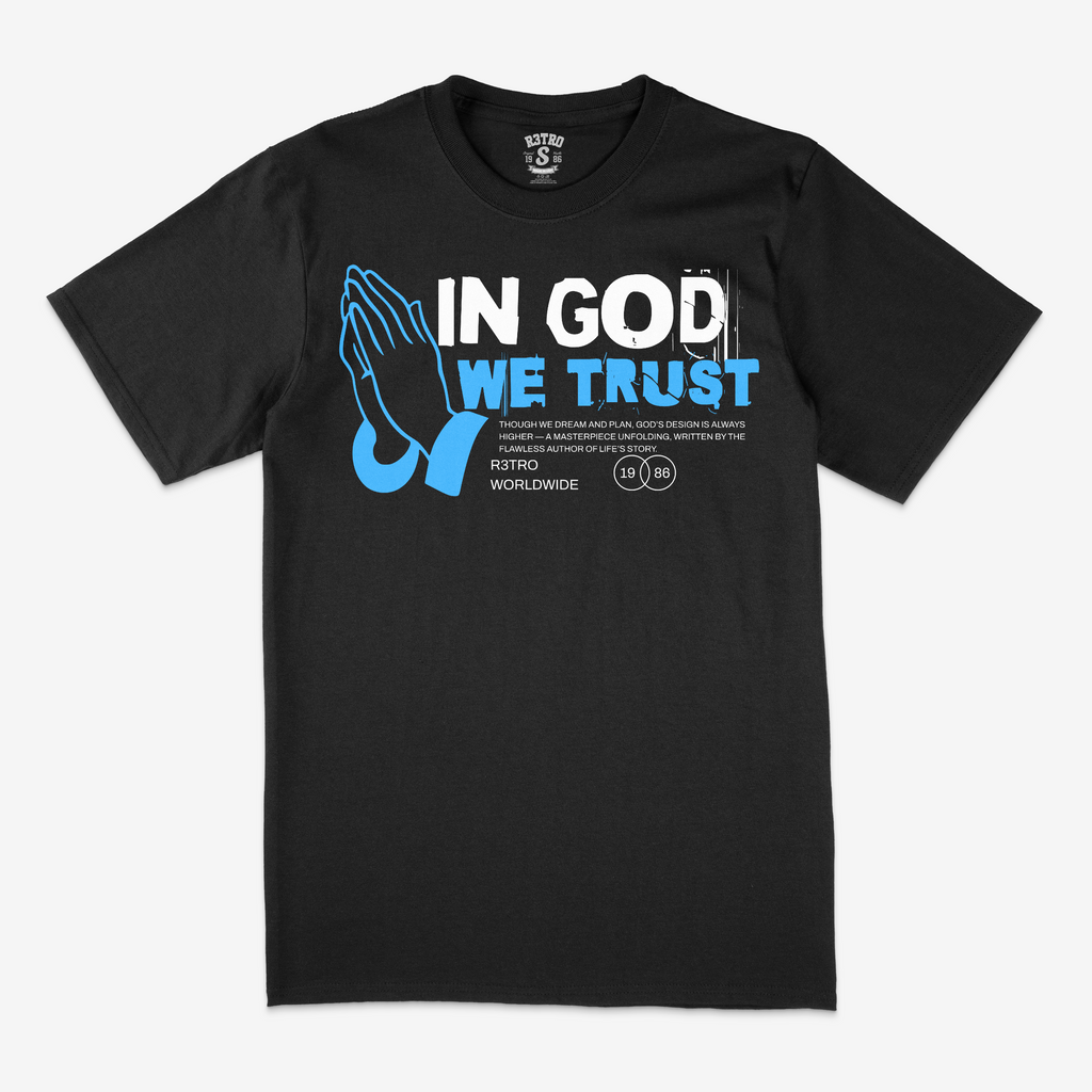 Black t-shirt with 'In God We Trust' text and praying hands graphic on a white background