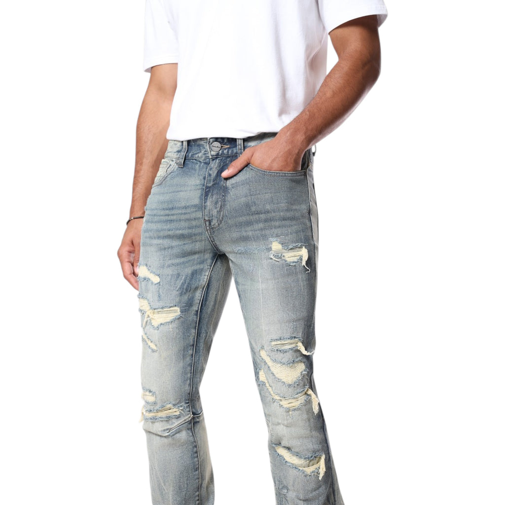 Person wearing light blue distressed jeans on a white background